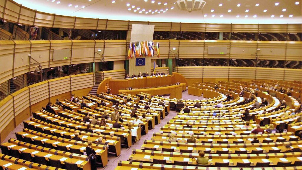 Aula istituzionale europea con banchi e postazioni di lavoro