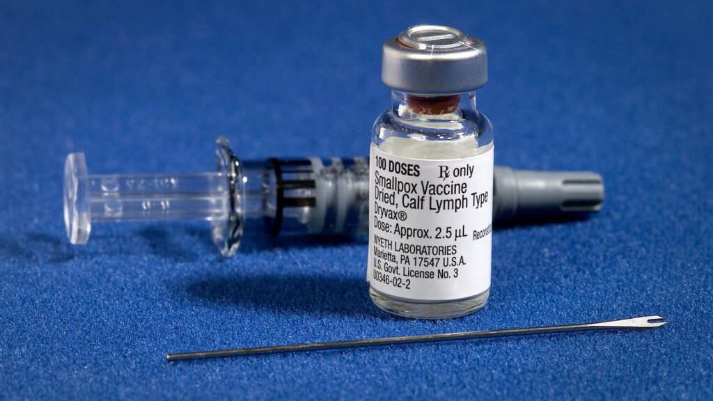 Flacone di vaccino e strumenti per vaccinazione su fondo blu